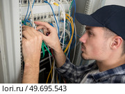 closeup of electrician engineer works with electric cable wires. Стоковое фото, агентство Ingram Publishing / Фотобанк Лори