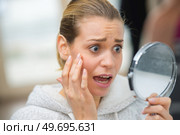 anguished young lady noticing wrinkles in the mirror. Стоковое фото, агентство Ingram Publishing / Фотобанк Лори