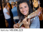 posing while holding a guitar. Стоковое фото, агентство Ingram Publishing / Фотобанк Лори