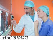 woman surgeon reviewing xrays with colleague. Стоковое фото, агентство Ingram Publishing / Фотобанк Лори