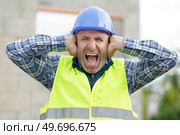 upset construction worker covering ears. Стоковое фото, агентство Ingram Publishing / Фотобанк Лори