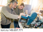 two carpenters using a circular saw. Стоковое фото, агентство Ingram Publishing / Фотобанк Лори
