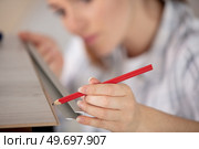 a woman using a pencil on a laminate board. Стоковое фото, агентство Ingram Publishing / Фотобанк Лори