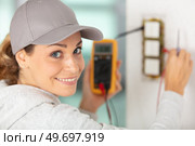 female electrician using multimeter on switches. Стоковое фото, агентство Ingram Publishing / Фотобанк Лори