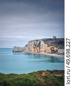 Idyllic view to Etretat coastline with the famous Notre-Dame de la Garde chapel on the Amont cliff. Shore washed by Atlantic ocean waters, Normandy, France. Стоковое фото, агентство Ingram Publishing / Фотобанк Лори