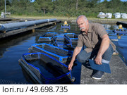man posing in the fish farm. Стоковое фото, агентство Ingram Publishing / Фотобанк Лори