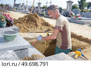 caucasian man digging grave at cemetery. Стоковое фото, агентство Ingram Publishing / Фотобанк Лори
