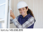 woman fixing handle on to pvc window. Стоковое фото, агентство Ingram Publishing / Фотобанк Лори