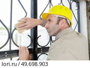 workman using sandpaper to prepare metal for repainting. Стоковое фото, агентство Ingram Publishing / Фотобанк Лори