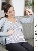 pregnant young woman doing selfie on phone. Стоковое фото, агентство Ingram Publishing / Фотобанк Лори