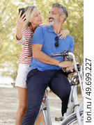senior couple with bicycles taking selfie. Стоковое фото, агентство Ingram Publishing / Фотобанк Лори