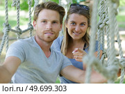 young couple on rope bridge activity course. Стоковое фото, агентство Ingram Publishing / Фотобанк Лори
