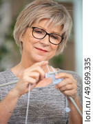 cheerful elderly woman holding knitting needles. Стоковое фото, агентство Ingram Publishing / Фотобанк Лори