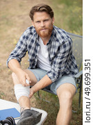 young man looks upset with his injured leg. Стоковое фото, агентство Ingram Publishing / Фотобанк Лори
