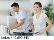 young housewife steering frying pan. Стоковое фото, агентство Ingram Publishing / Фотобанк Лори