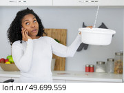 woman calling plumber to fix water leaking from ceiling. Стоковое фото, агентство Ingram Publishing / Фотобанк Лори