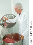 portrait of a butcher mincing meat. Стоковое фото, агентство Ingram Publishing / Фотобанк Лори