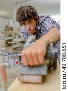 Young carpenter using a sander. Стоковое фото, агентство Ingram Publishing / Фотобанк Лори