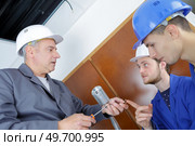 Student questioning instructor holding screwdriver and screws. Стоковое фото, агентство Ingram Publishing / Фотобанк Лори