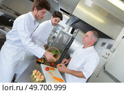 a chef supervising trainees cooking. Стоковое фото, агентство Ingram Publishing / Фотобанк Лори