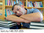 tired man with stack of books. Стоковое фото, агентство Ingram Publishing / Фотобанк Лори
