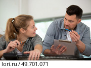female apprentice electrician working on appliance under supervision. Стоковое фото, агентство Ingram Publishing / Фотобанк Лори