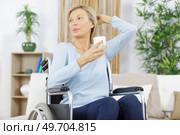 senior woman with disability recovery at home wheelchair holding cup. Стоковое фото, агентство Ingram Publishing / Фотобанк Лори
