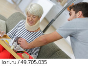 Man serving meal on tray to woman with neck injury. Стоковое фото, агентство Ingram Publishing / Фотобанк Лори