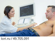 doctors is holding a probe while performing abdominal ultrasound exam. Стоковое фото, агентство Ingram Publishing / Фотобанк Лори