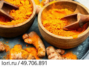 Dried turmeric roots in a wooden bowl. Turmeric spice.. Turmeric root and curcuma powder. Стоковое фото, агентство Ingram Publishing / Фотобанк Лори