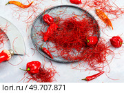 Spicy seasoning, spice, cut from red pepper. Thinly sliced pepper.. Cutting red chilly peppers. Стоковое фото, агентство Ingram Publishing / Фотобанк Лори