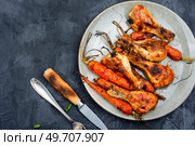 Tasty chicken legs baked with carrots on plate. Space for text.. Roasted chicken drumstick. Стоковое фото, агентство Ingram Publishing / Фотобанк Лори