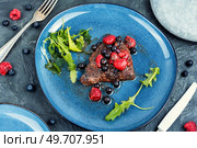 Beef steak roasted in blueberry and raspberry sauce. Top view.. Fried beef fillet medallion steak. Стоковое фото, агентство Ingram Publishing / Фотобанк Лори