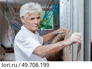 man is insulating a new house. Стоковое фото, агентство Ingram Publishing / Фотобанк Лори