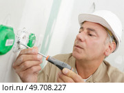 man holding small flat blade screwdriver. Стоковое фото, агентство Ingram Publishing / Фотобанк Лори
