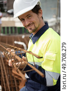 male worker holding a metal reinforcing bar structure. Стоковое фото, агентство Ingram Publishing / Фотобанк Лори