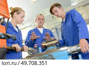 Tradesman explaining exquipment to trainees. Стоковое фото, агентство Ingram Publishing / Фотобанк Лори