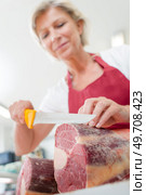 Female butcher slicing some beef. Стоковое фото, агентство Ingram Publishing / Фотобанк Лори