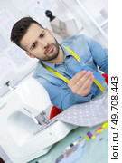 male tailor using sewing machine holding zip. Стоковое фото, агентство Ingram Publishing / Фотобанк Лори