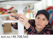 woman screwing a metal chair. Стоковое фото, агентство Ingram Publishing / Фотобанк Лори
