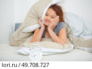 woman in bed looking ruefully at alarm clock. Стоковое фото, агентство Ingram Publishing / Фотобанк Лори