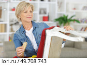 young woman sanding a chair. Стоковое фото, агентство Ingram Publishing / Фотобанк Лори