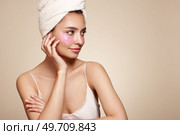 A young beautiful smiling woman with cosmetic patches on her eyes. Cosmetic procedures skin care around the eyes. Perfect healthy facial skin. Стоковое фото, агентство Ingram Publishing / Фотобанк Лори