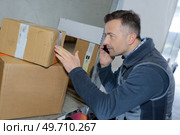 handsome deliveryman checking load talking on the phone. Стоковое фото, агентство Ingram Publishing / Фотобанк Лори