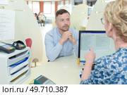 patient sat at receptionists booth in hospital. Стоковое фото, агентство Ingram Publishing / Фотобанк Лори