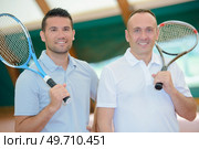 Two men with tennis rackets over their shoulders. Стоковое фото, агентство Ingram Publishing / Фотобанк Лори