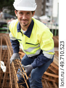 male builder moving reinforcement bars. Стоковое фото, агентство Ingram Publishing / Фотобанк Лори