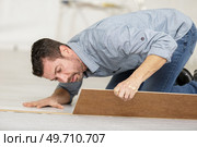 man installing new laminated wooden floor close up. Стоковое фото, агентство Ingram Publishing / Фотобанк Лори