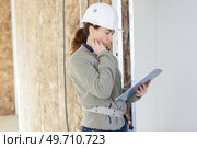 unsure woman builder holding a clipboard. Стоковое фото, агентство Ingram Publishing / Фотобанк Лори