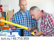 man in printing house showing client printed documents. Стоковое фото, агентство Ingram Publishing / Фотобанк Лори